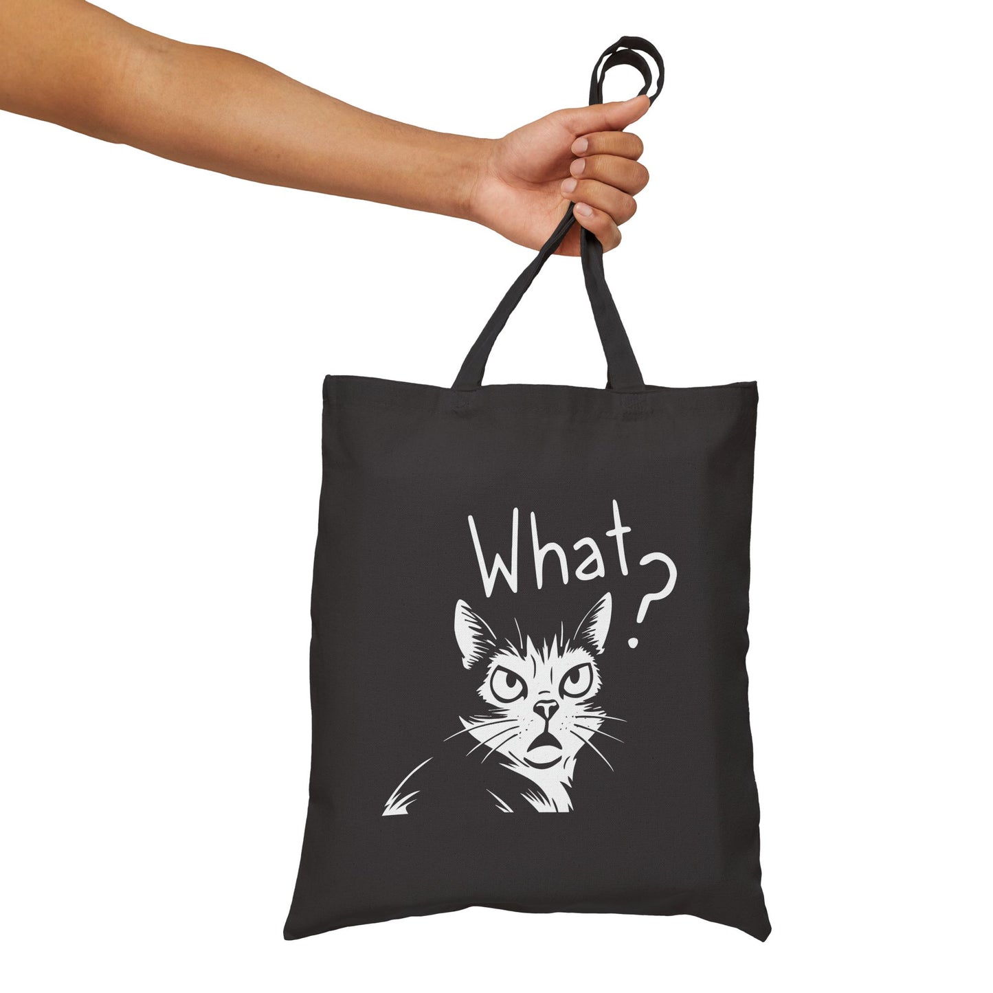 Black tote bag with a cat graphic and 'What?' text held by a hand on a white background