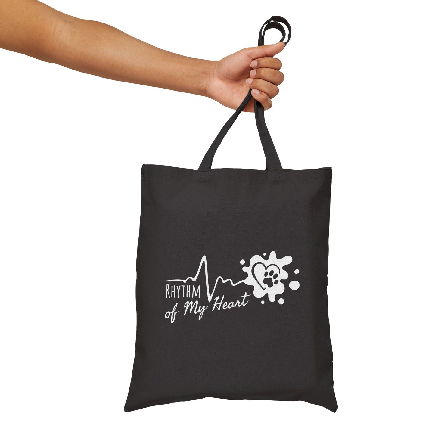 Black tote bag with 'Rhythm of My Heart' design held by a hand on a white background