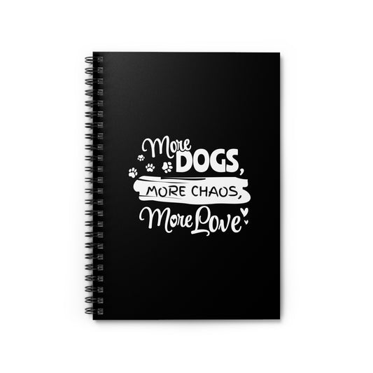 Black notebook with white text 'More Dogs, More Chaos, More Love' on a white background
