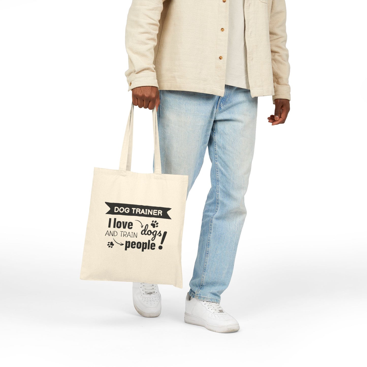 Person holding a tote bag with 'Dog Trainer' text on a white background
