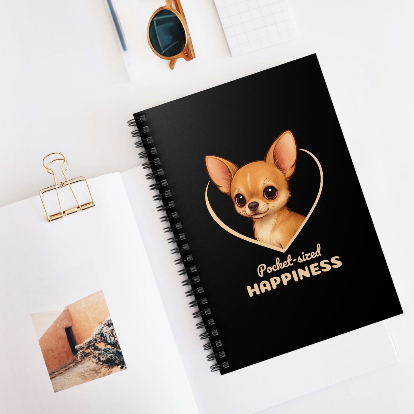 Black notebook with a dog illustration and text on a white surface