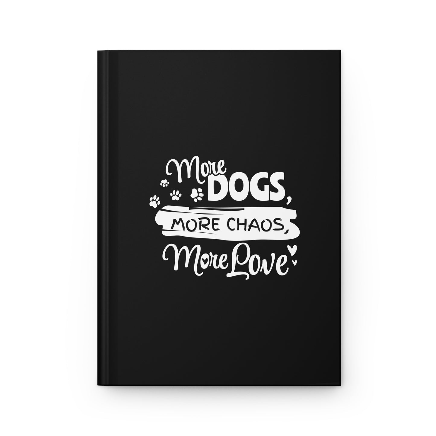 Black notebook with white text 'More Dogs, More Chaos, More Love' on a white background