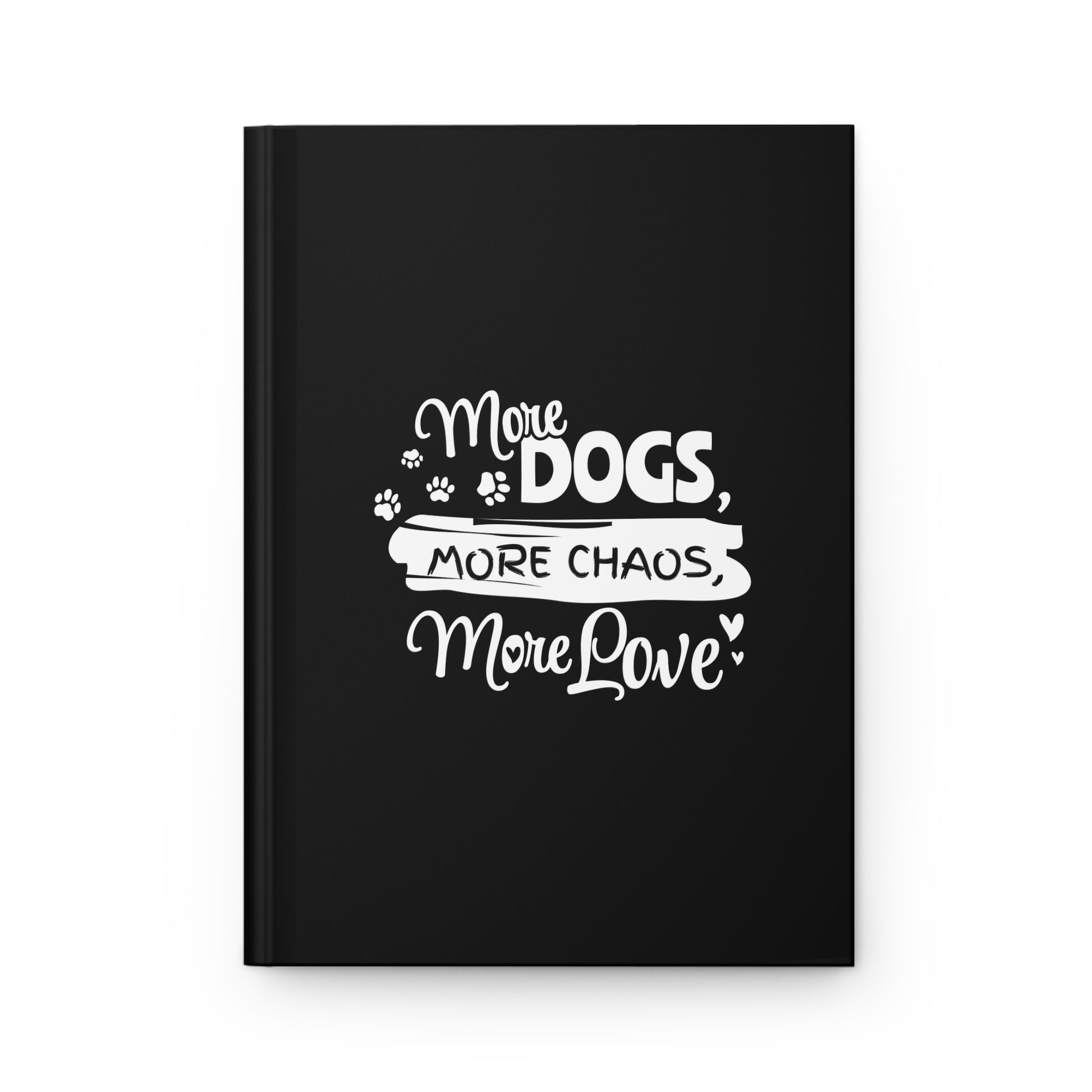 Black notebook with white text 'More Dogs, More Chaos, More Love' on a white background