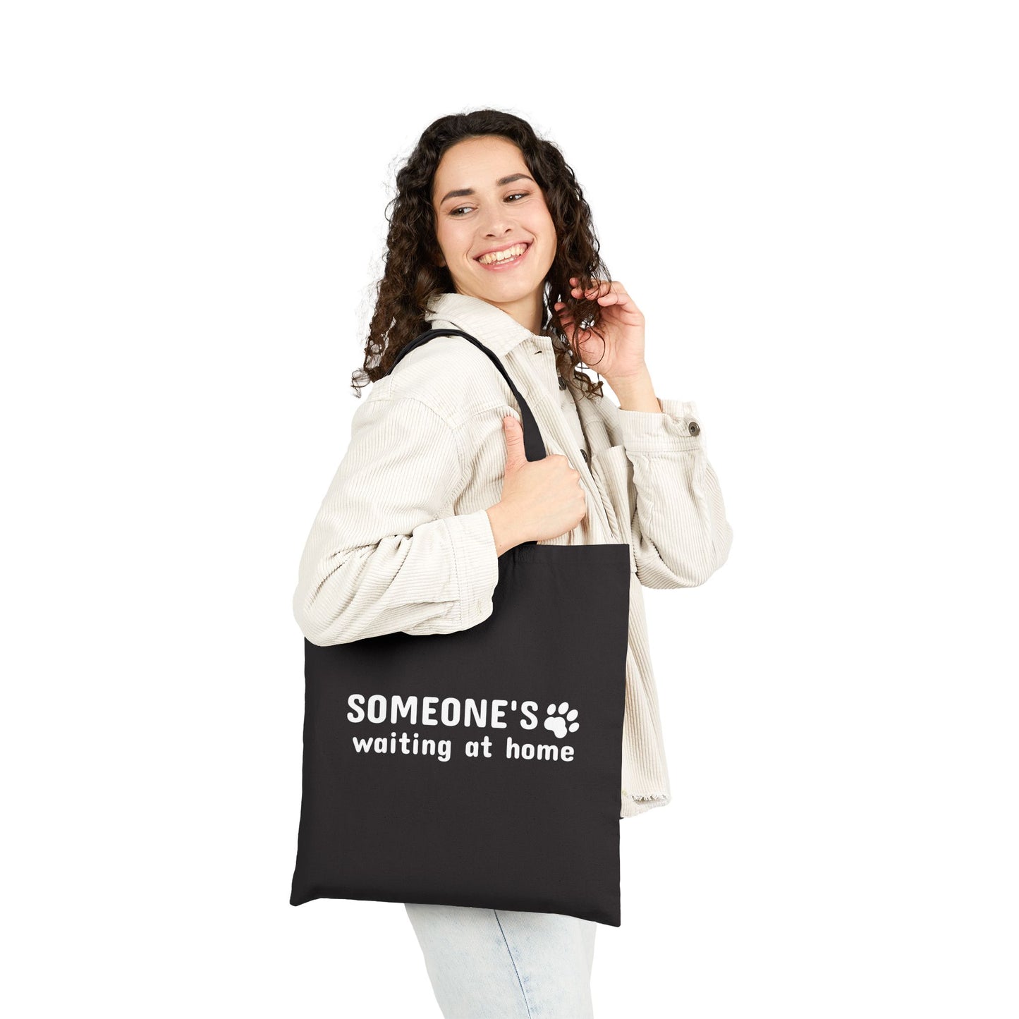 Woman holding a black tote bag with text on a white background