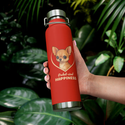 Red water bottle with a dog illustration and text held by a hand against a leafy background