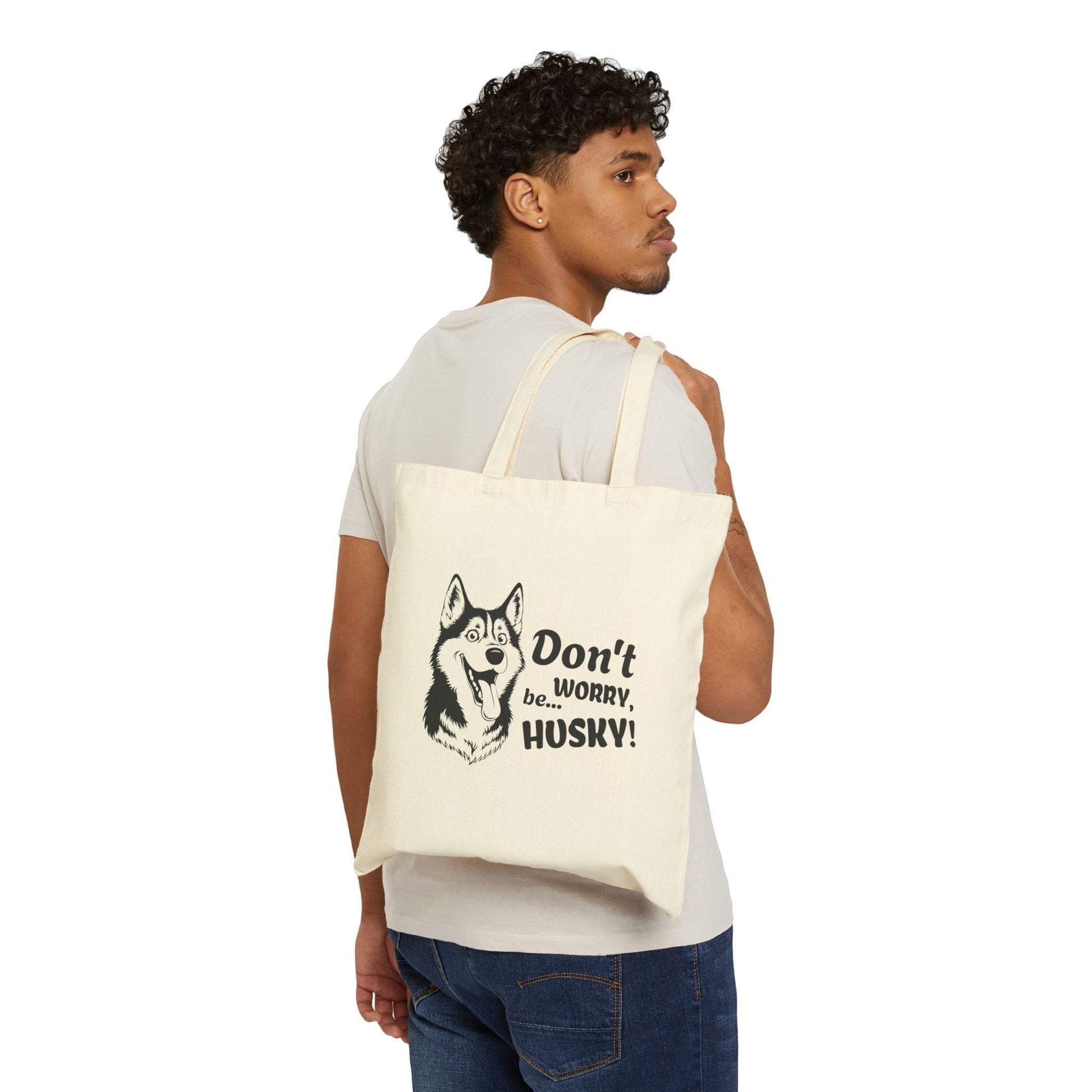 Man carrying a tote bag with a husky design and text on a white background