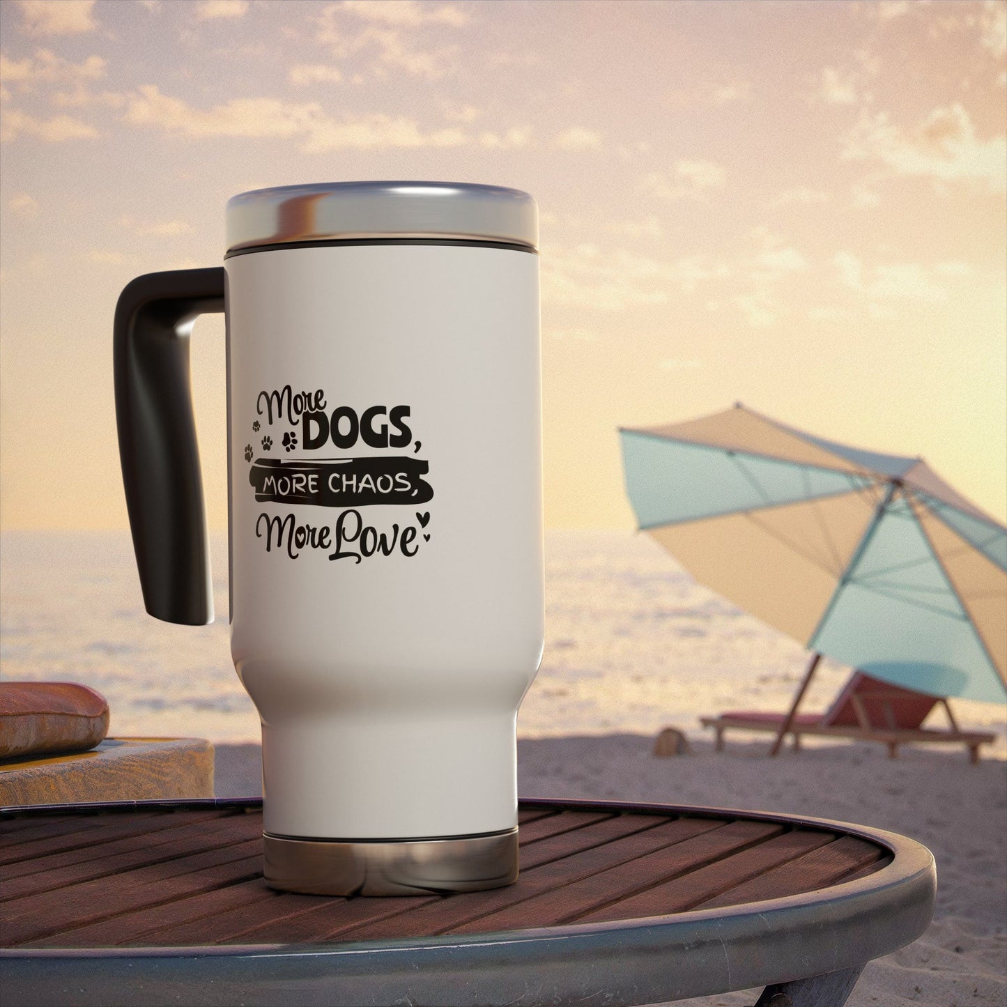 White travel mug with black text on a beach table with a beach umbrella and sand in the background