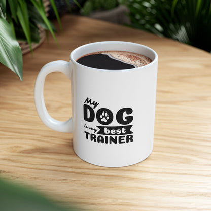 White mug with 'My dog is my best trainer' text on a wooden table