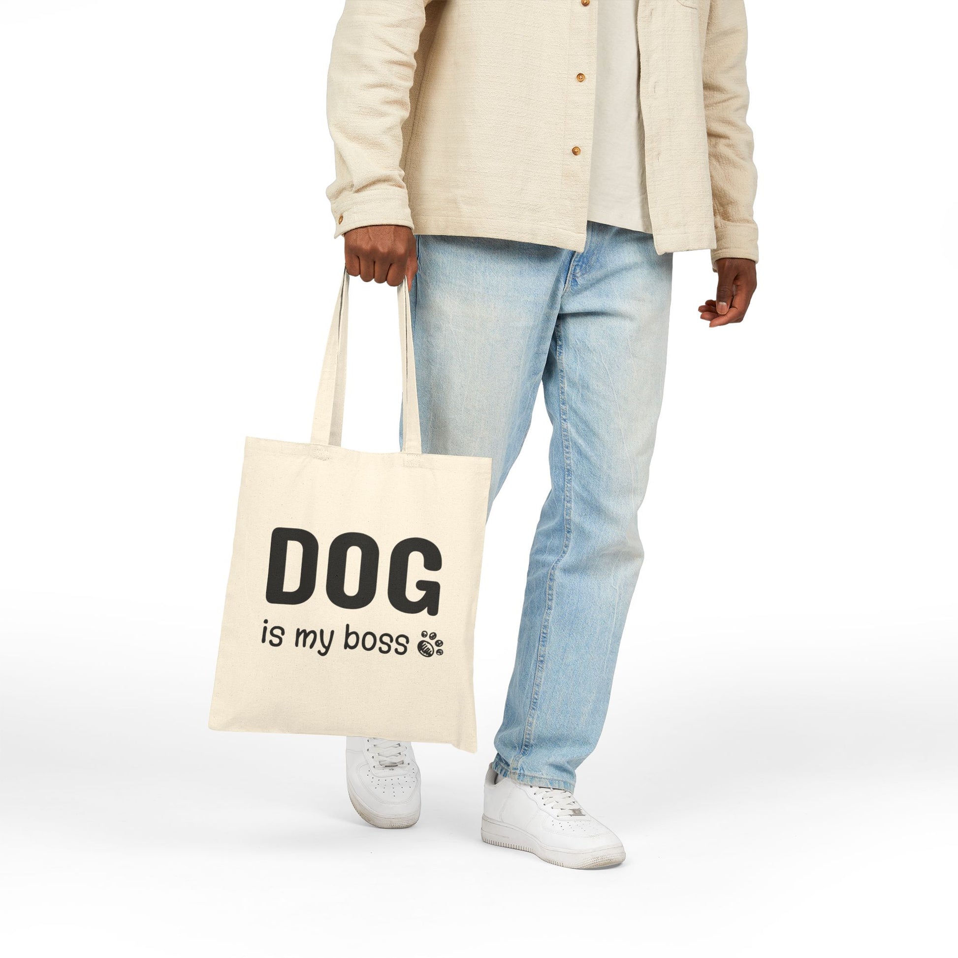 Person holding a tote bag with 'DOG is my boss' text on a white background