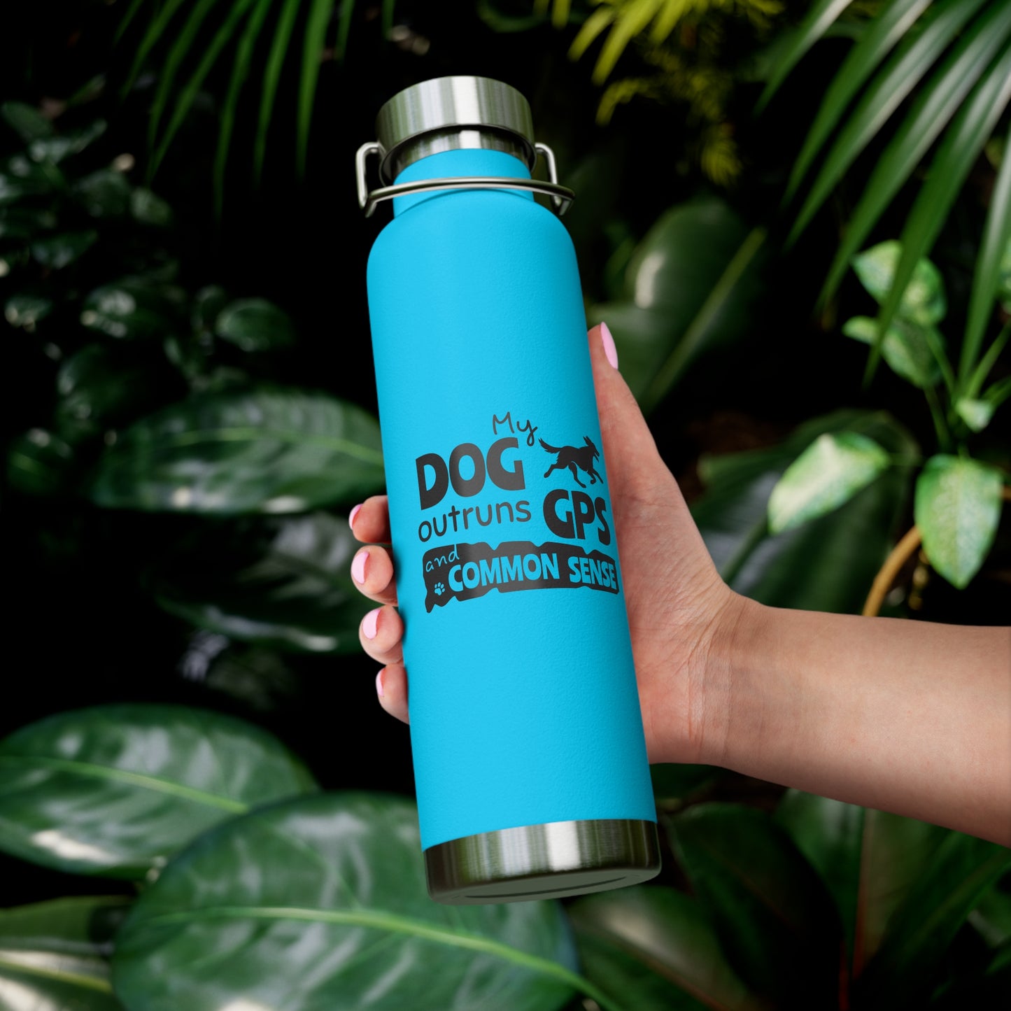 Blue water bottle with text held in front of green leaves