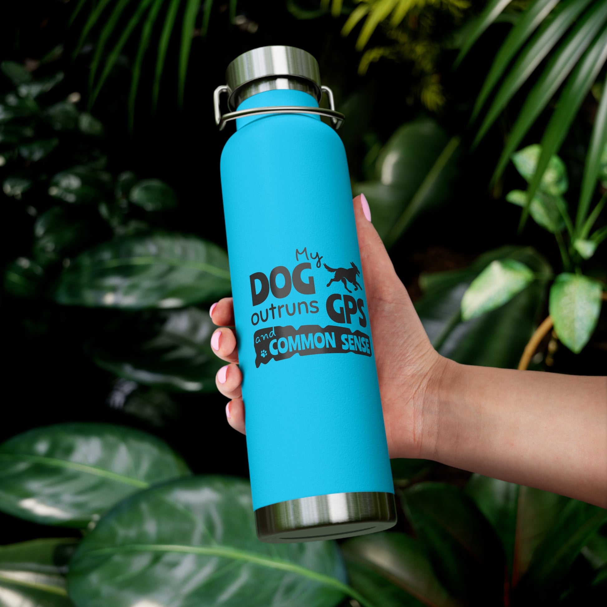Blue water bottle with text held in front of green leaves