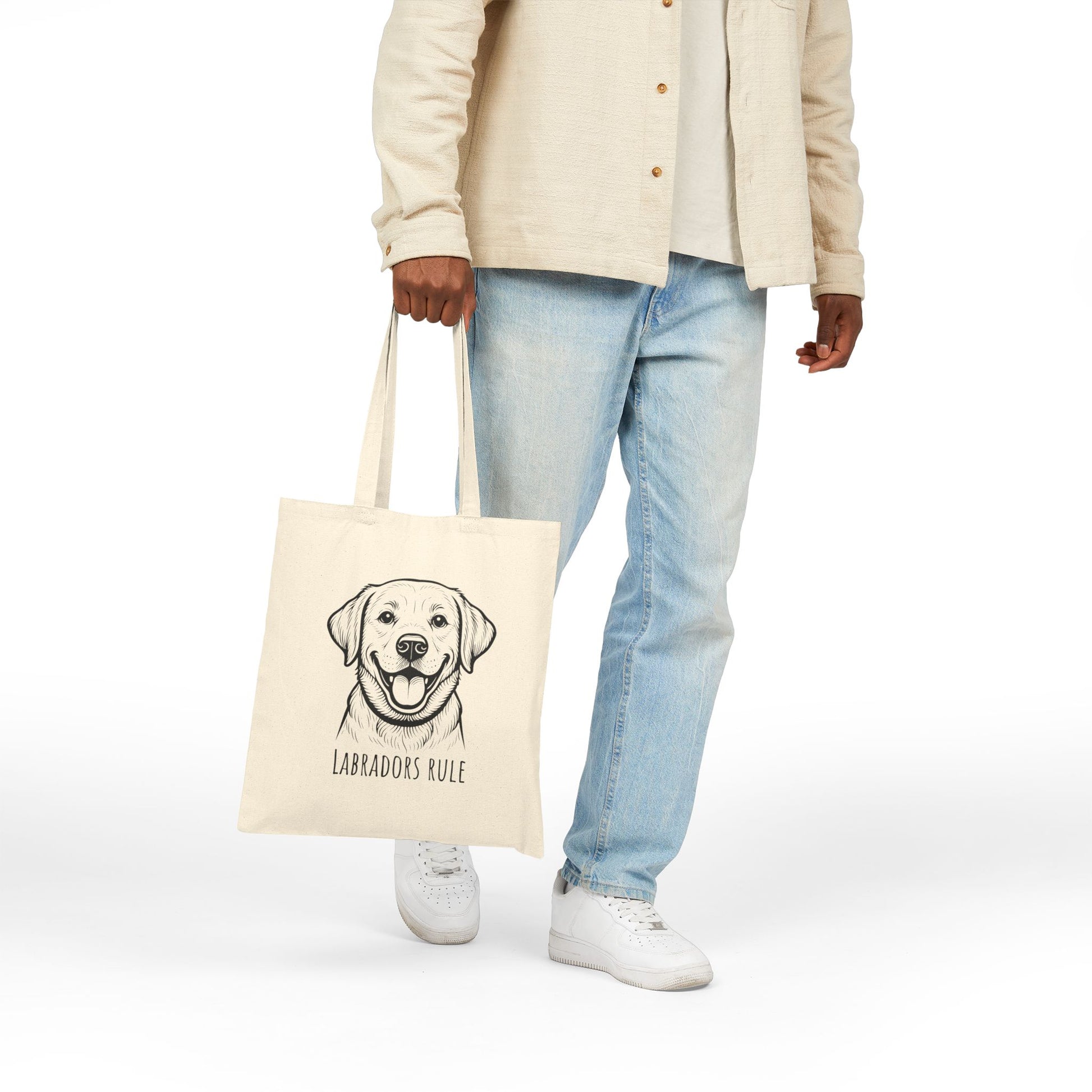 Person holding a tote bag with a Labrador illustration and 'Labradors Rule' text on a white background