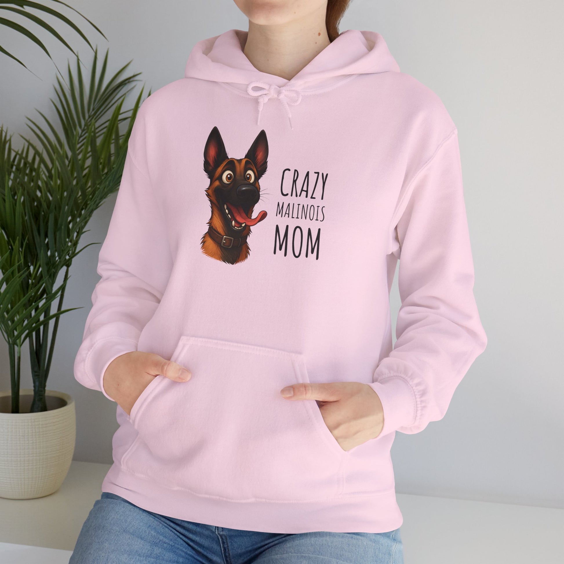 Person wearing a pink hoodie with a dog graphic and text in a home setting