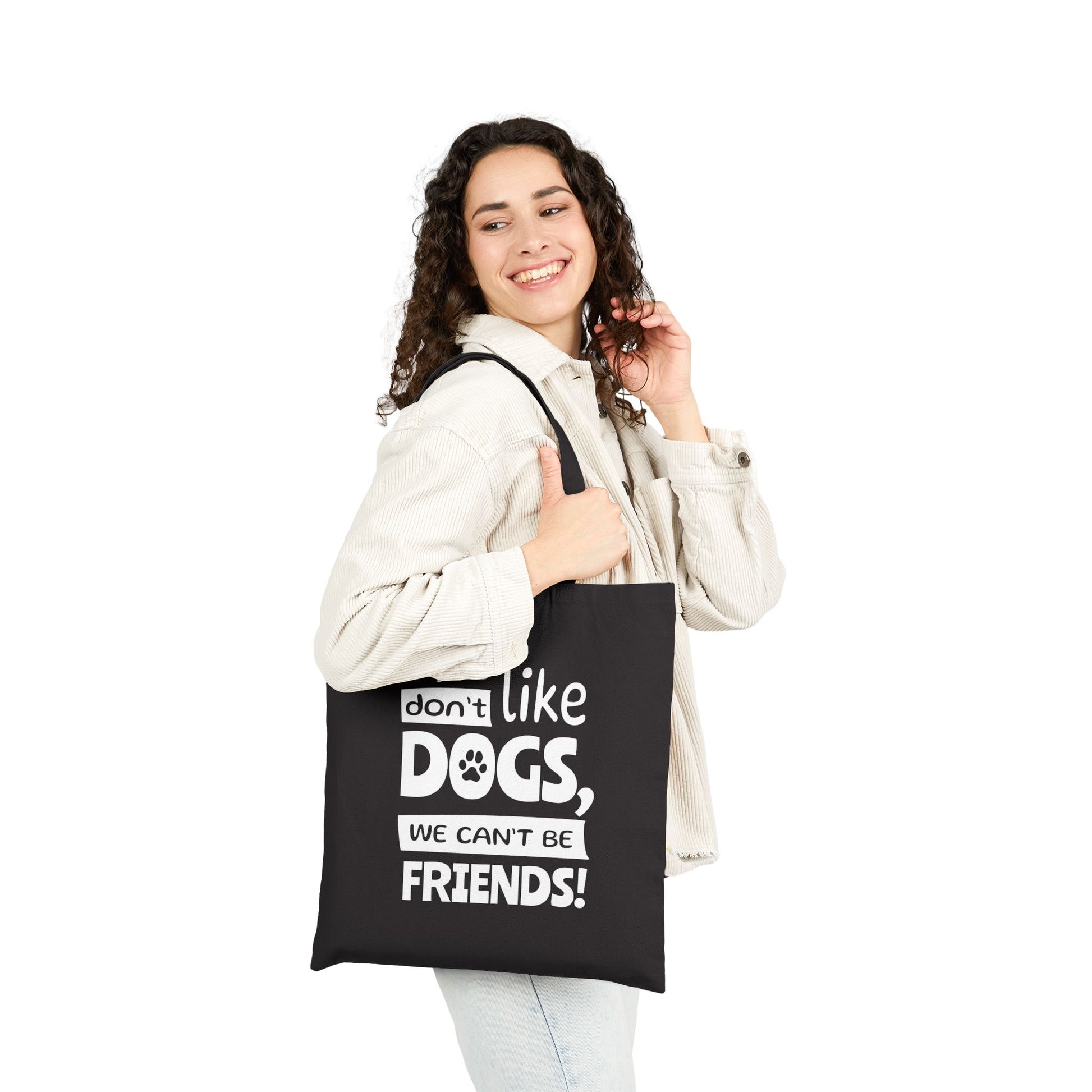 Person holding a black tote bag with text, white background