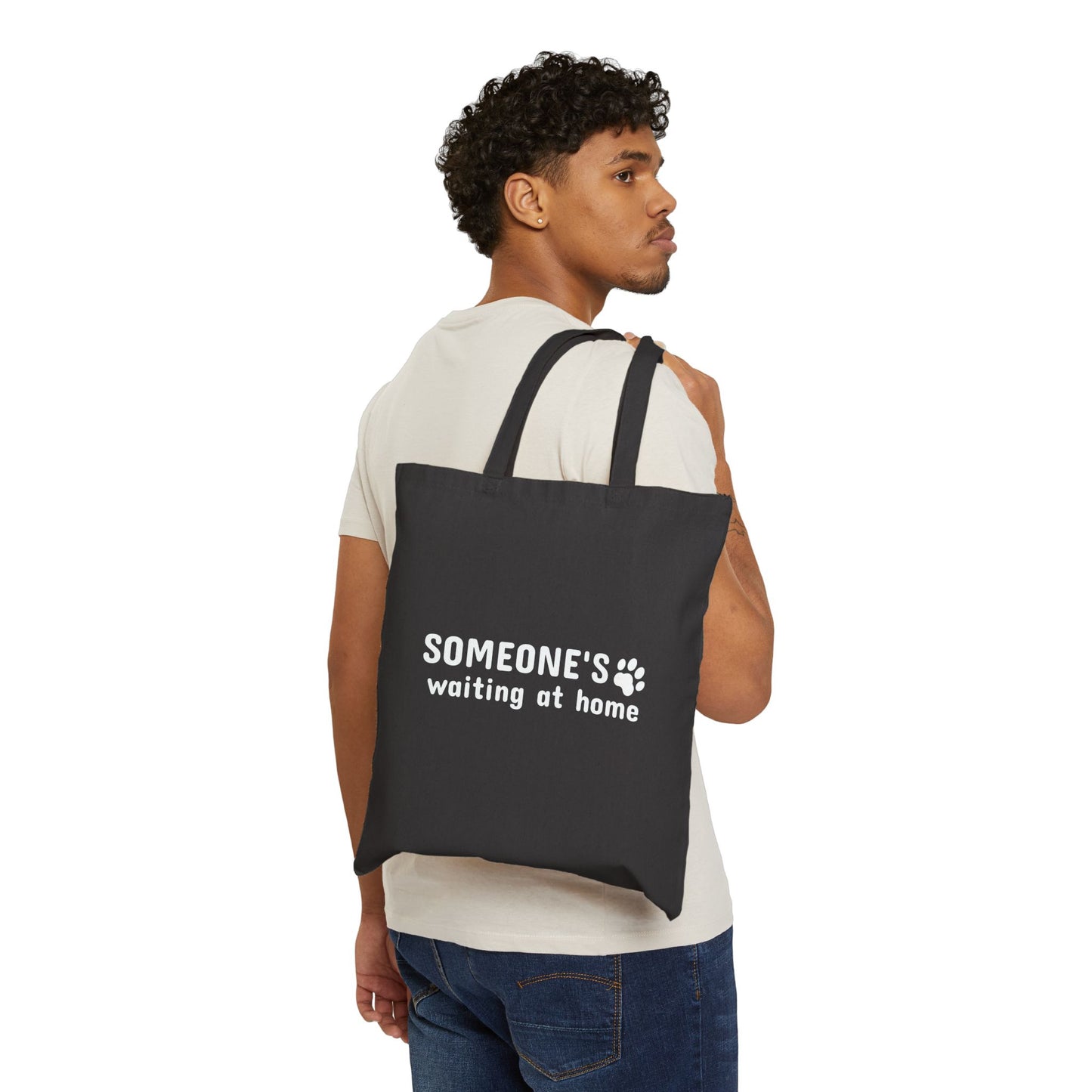 Man carrying a black tote bag with text on a white background