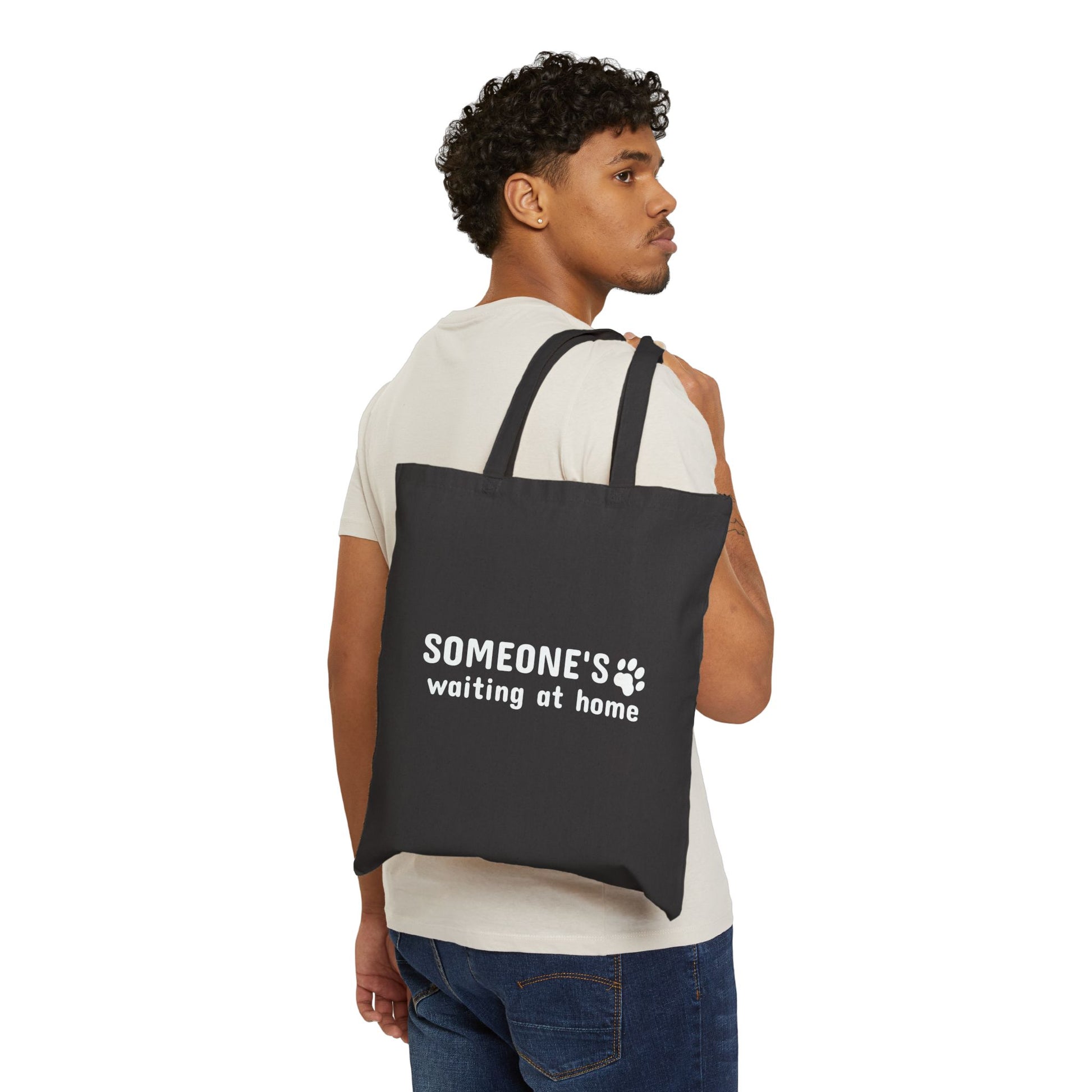 Man carrying a black tote bag with text on a white background