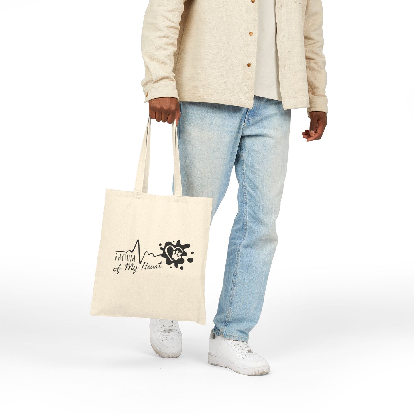 Person holding a tote bag with a logo on a white background