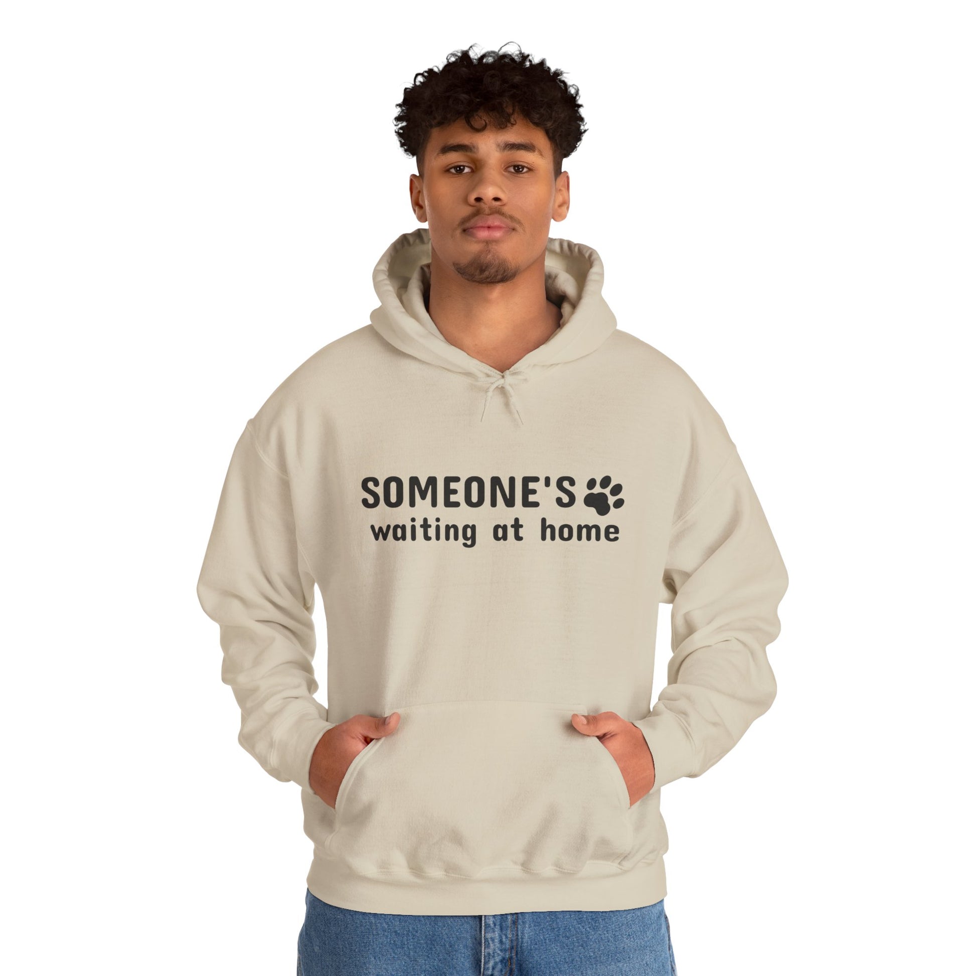 Person wearing a beige hoodie with text and paw print design on a white background