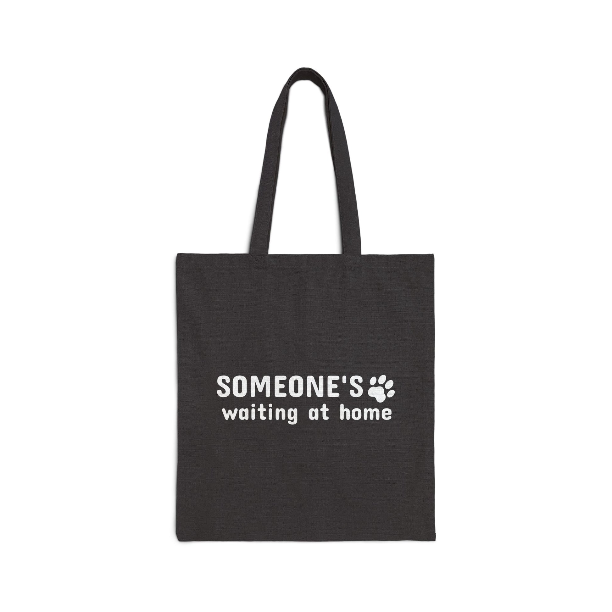 Black tote bag with text 'SOMEONE'S waiting at home' on a white background