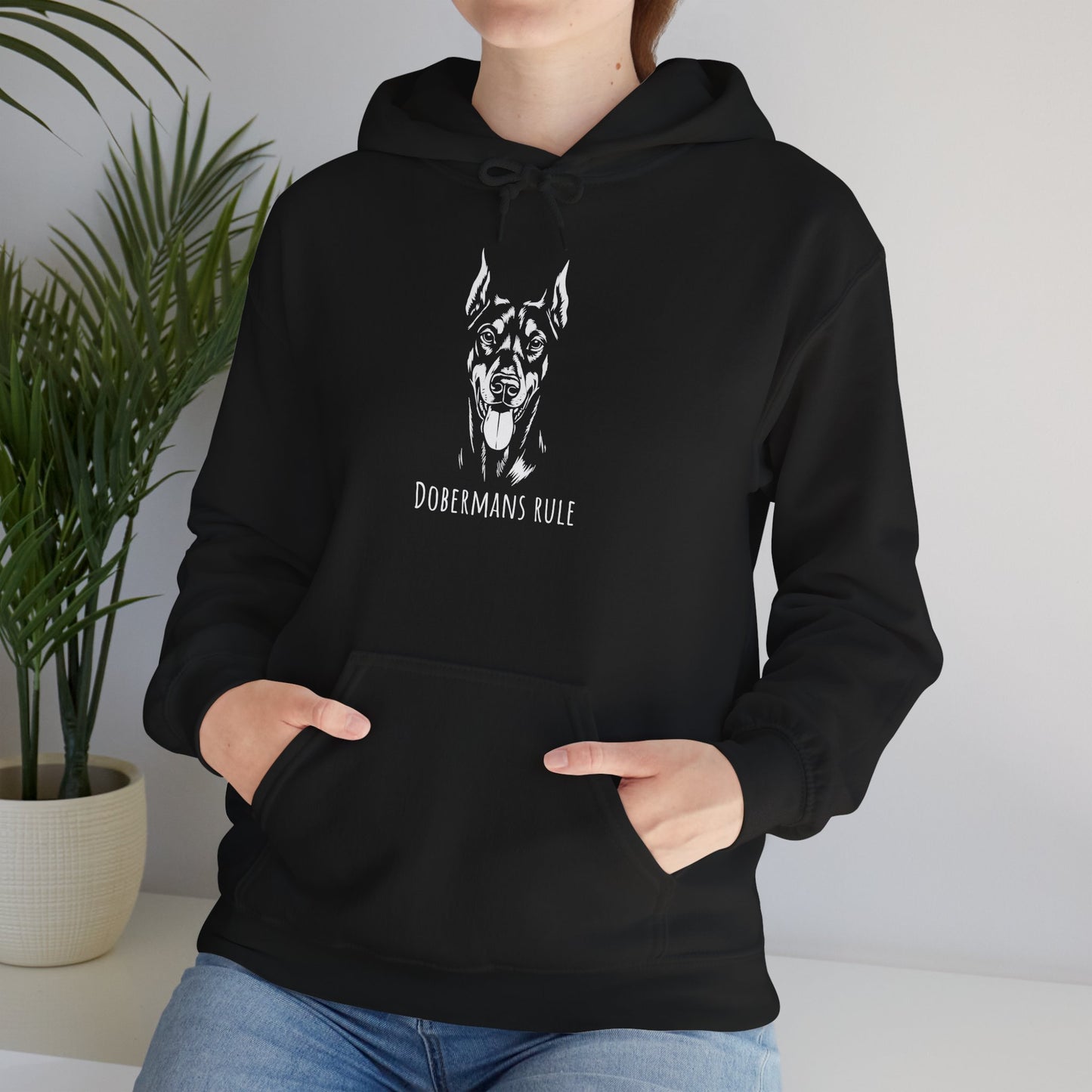 Person wearing a black hoodie with a dog graphic and 'Dobermans Rule' text, standing indoors.