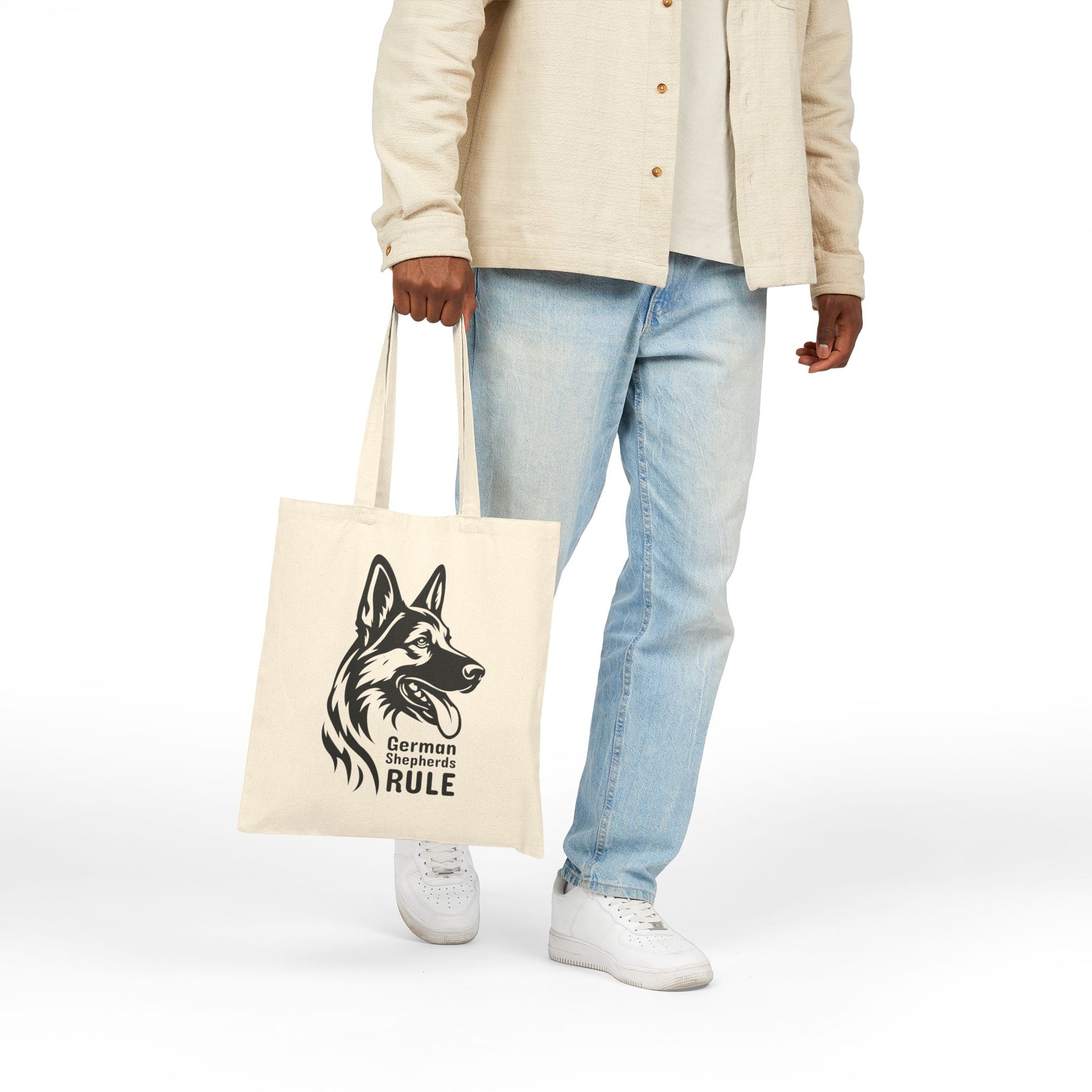 Person holding a tote bag with a German Shepherd design and text on a white background