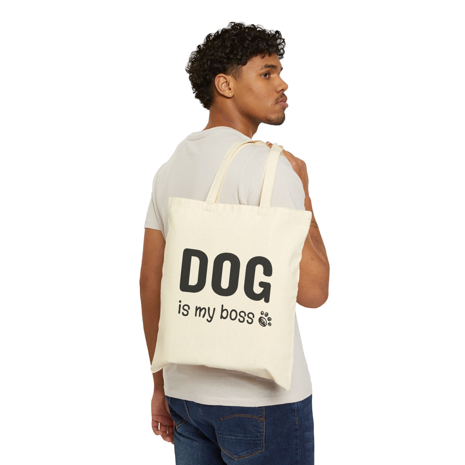 Man carrying a tote bag with 'DOG is my boss' text on a white background