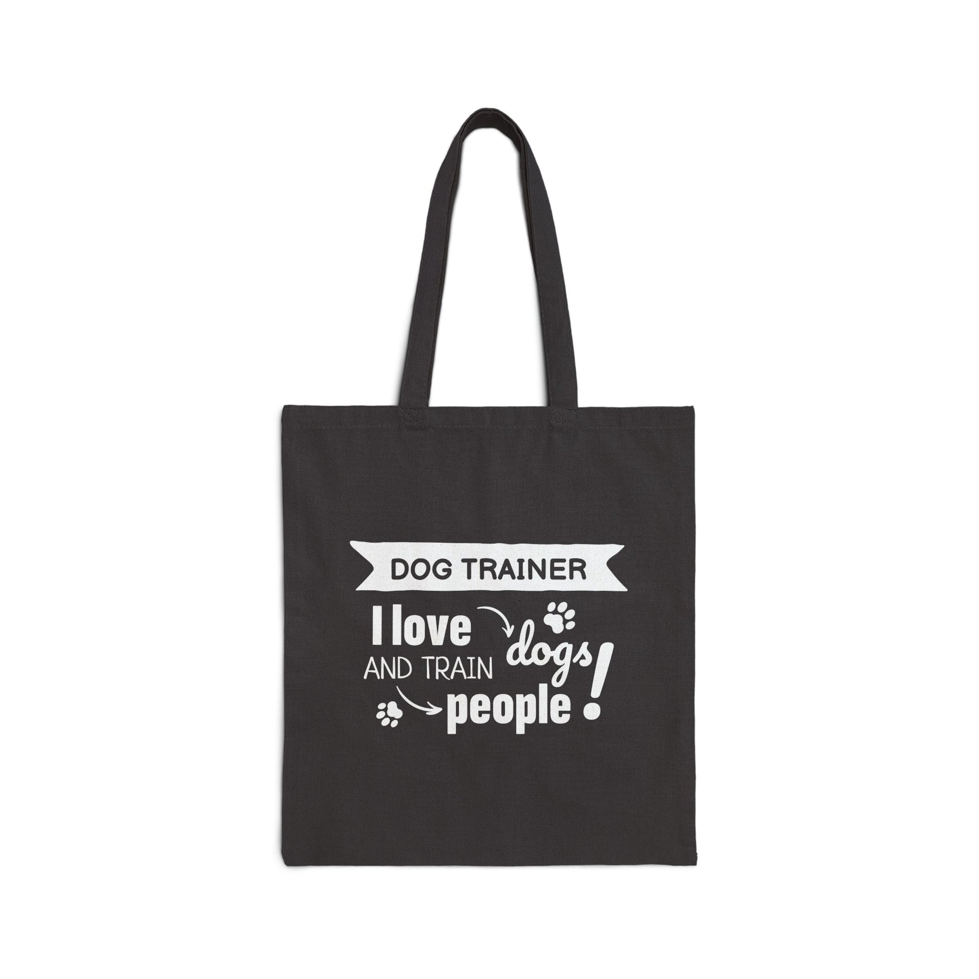 Black tote bag with white text 'Dog Trainer I love dogs and train people' on a white background