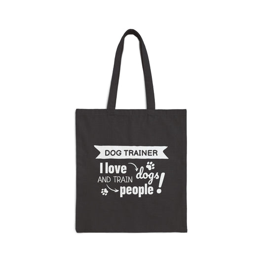 Black tote bag with white text 'Dog Trainer I love dogs and train people' on a white background