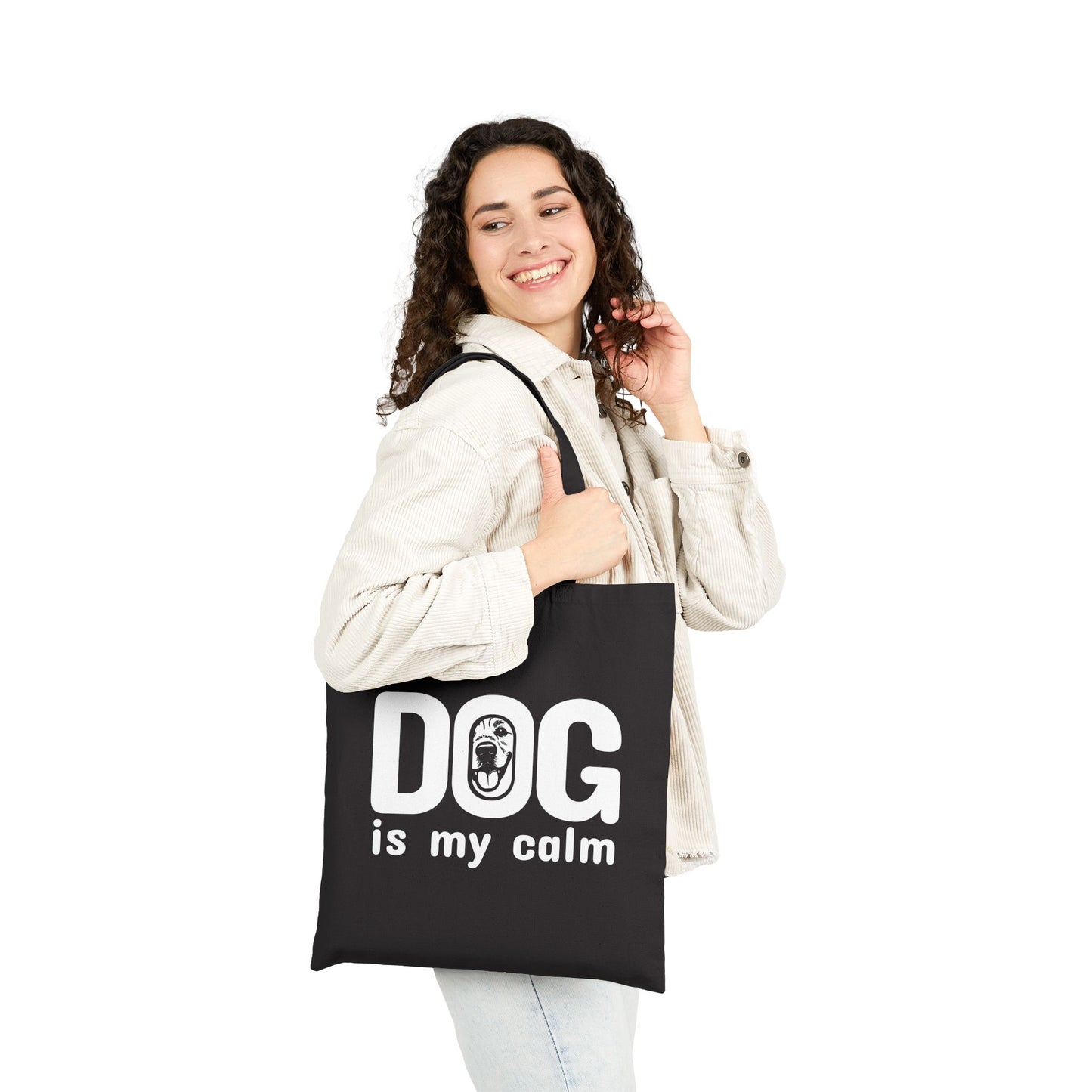 Woman holding a black tote bag with 'DOG is my calm' text on a white background