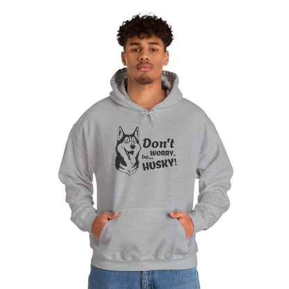 Person wearing a gray hoodie with a husky design and text on a white background