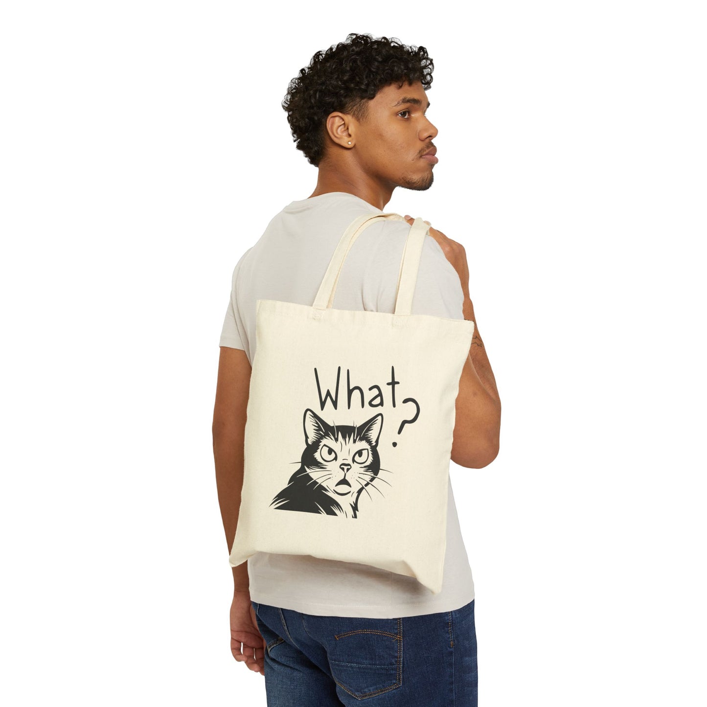Person holding a tote bag with a cat graphic and 'What?' text on a white background