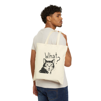 Person holding a tote bag with a cat graphic and 'What?' text on a white background