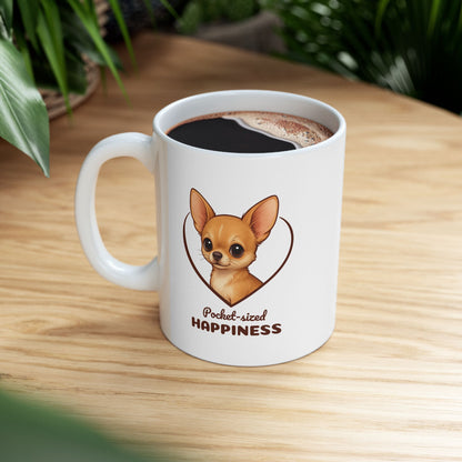 White mug with a dog illustration and 'Pocket-sized Happiness' text on a wooden table.