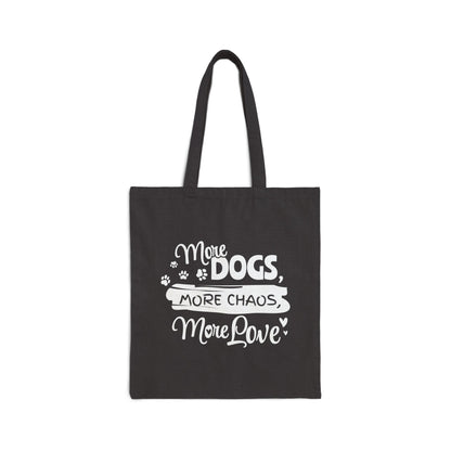 Black tote bag with white text 'More Dogs, More Chaos, More Love' on a white background
