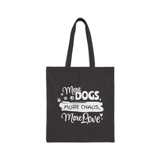 Black tote bag with white text 'More Dogs, More Chaos, More Love' on a white background