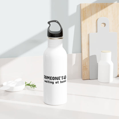 White water bottle with text on a white surface with wooden cutting boards in the background