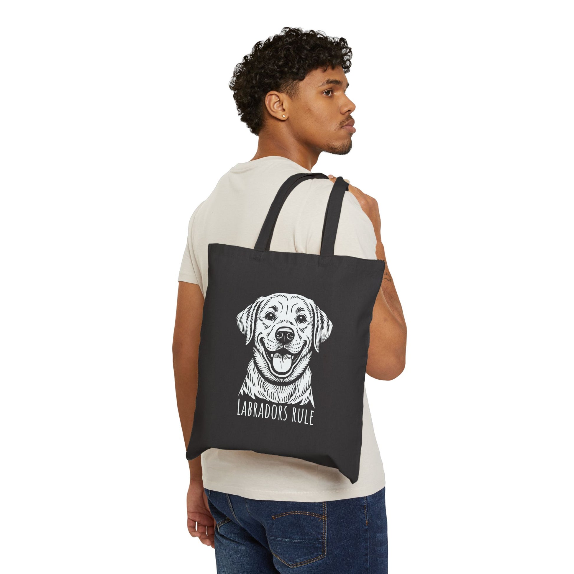 Man carrying a black tote bag with a dog illustration and 'Labradors Rule' text on a white background