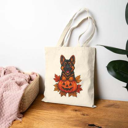Tote bag with a dog and pumpkin design on a wooden surface.