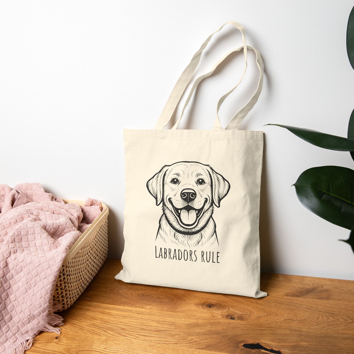 Beige tote bag with a dog illustration and 'Labradors Rule' text on a wooden surface.