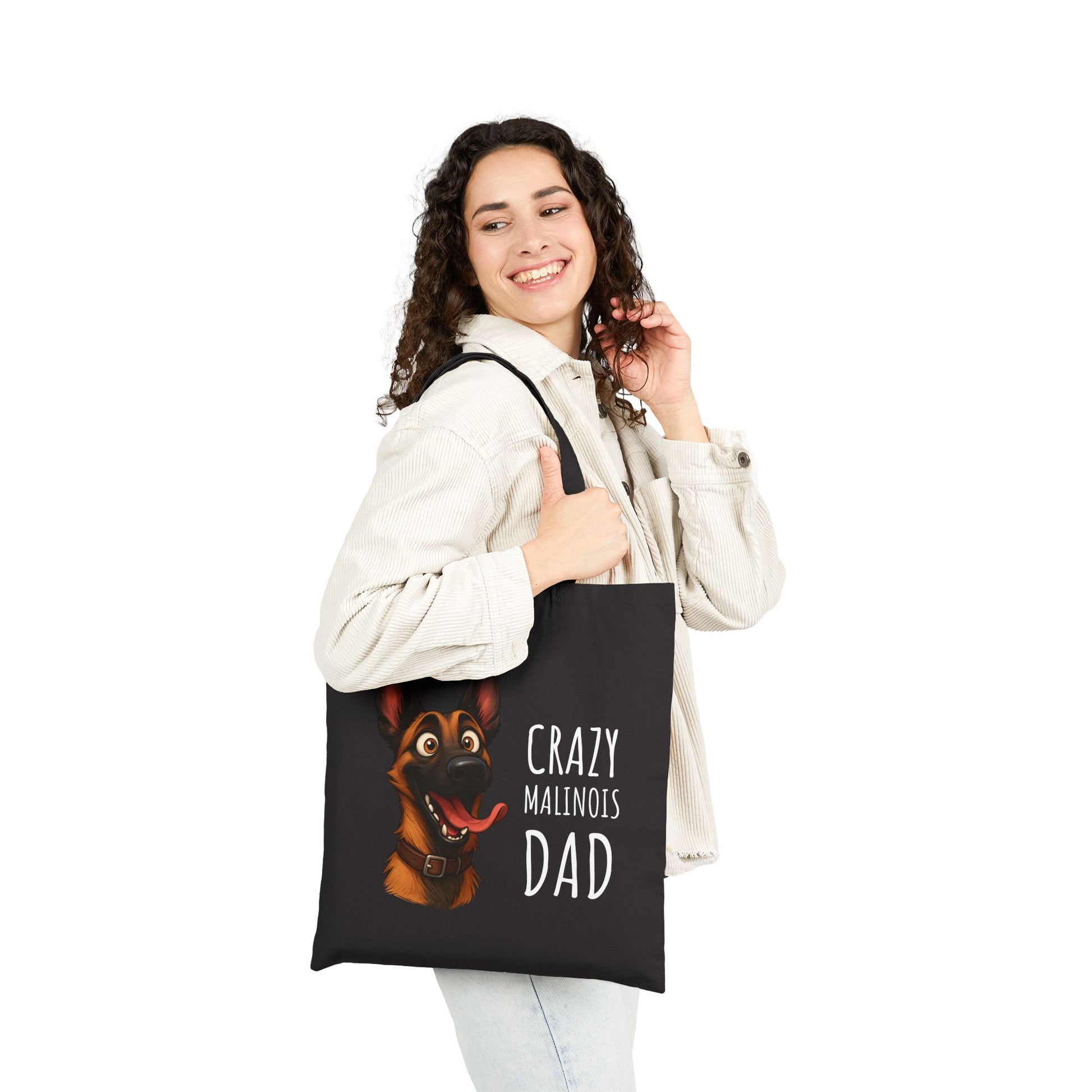 Person holding a tote bag with a dog illustration and text on a white background