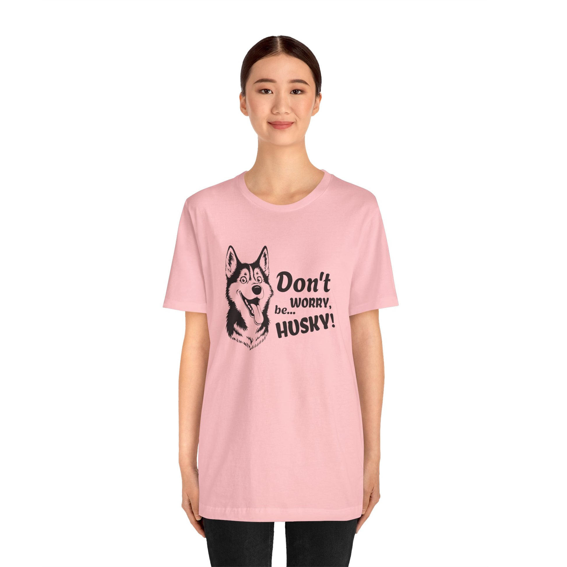 Person wearing a pink t-shirt with a husky graphic and text on a white background
