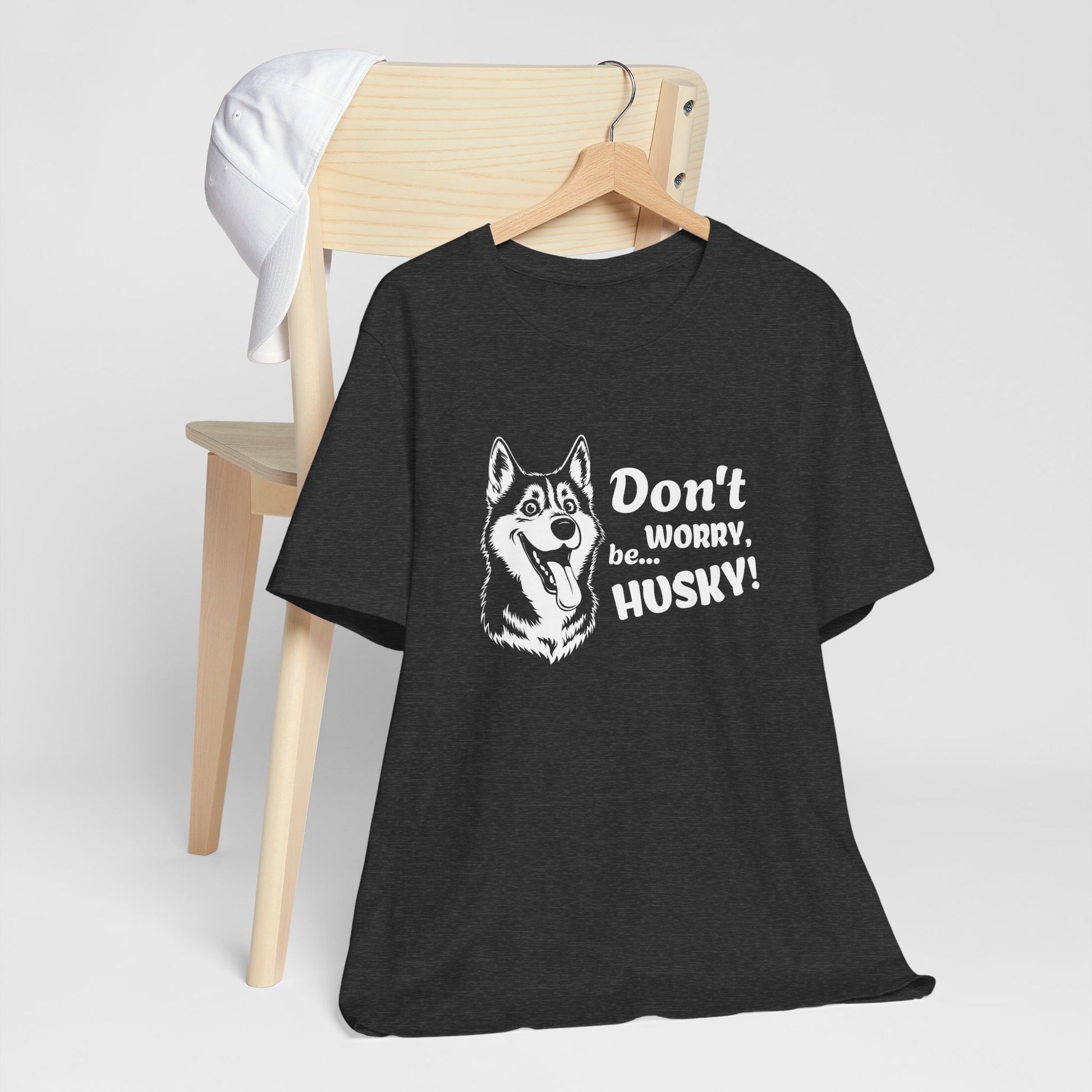 Black t-shirt with husky graphic and text on a wooden chair against a white background