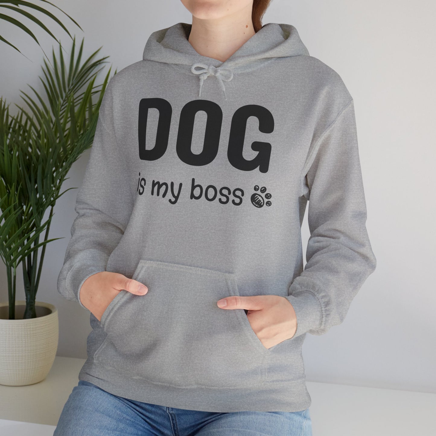 Person wearing a gray hoodie with 'DOG is my boss' text, standing indoors with a plant in the background.