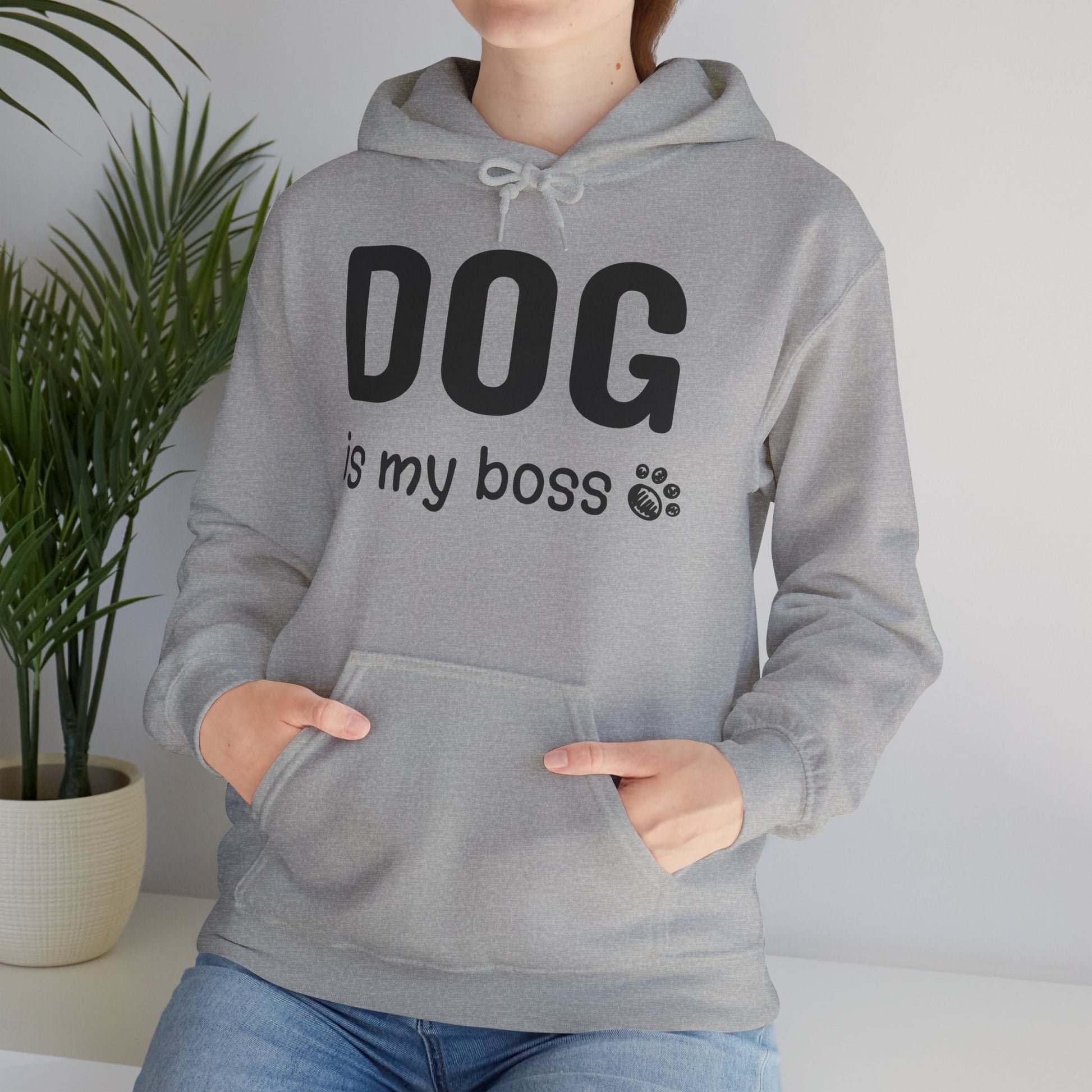 Person wearing a gray hoodie with 'DOG is my boss' text, standing indoors with a plant in the background.