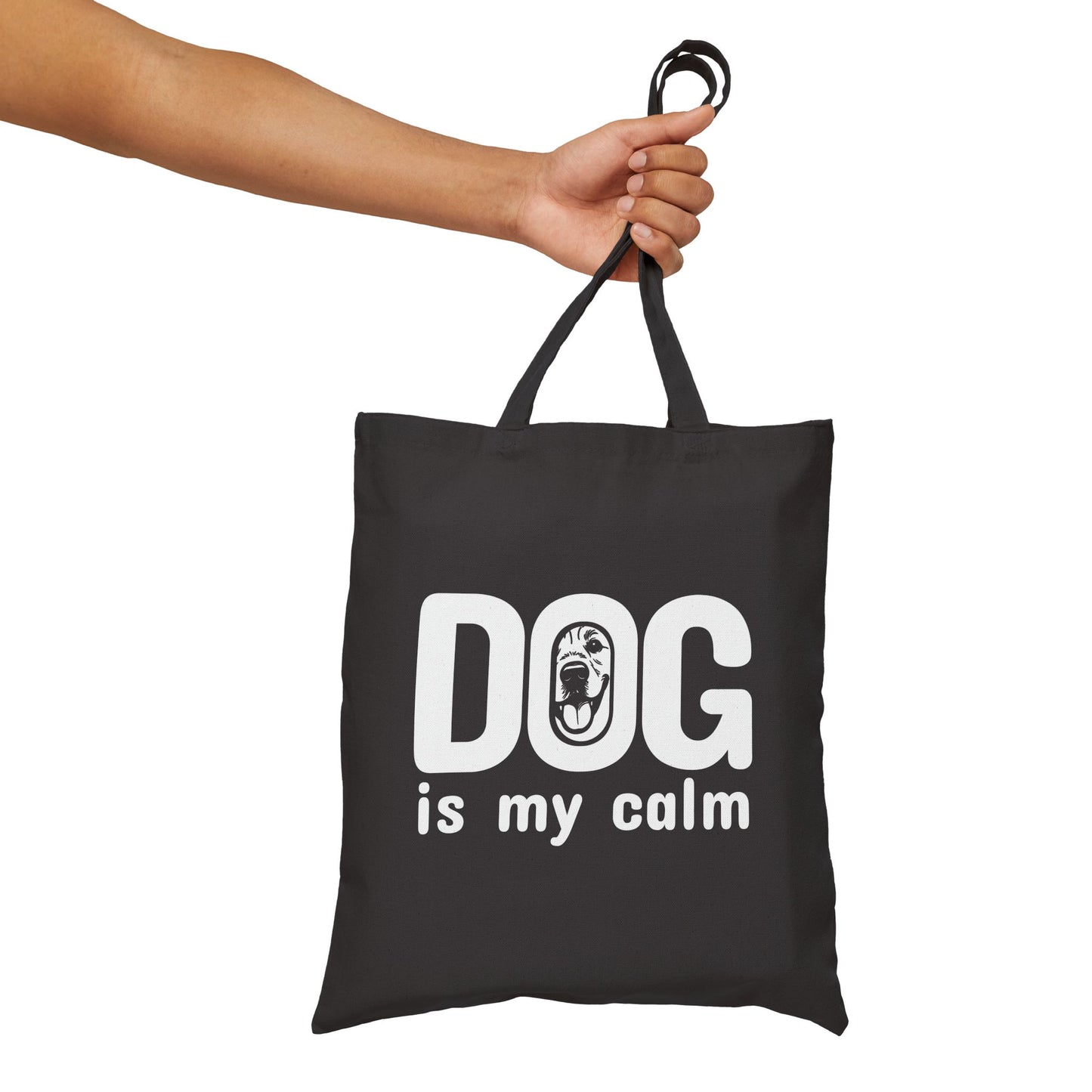 Black tote bag with 'DOG is my calm' text held by a hand on a white background