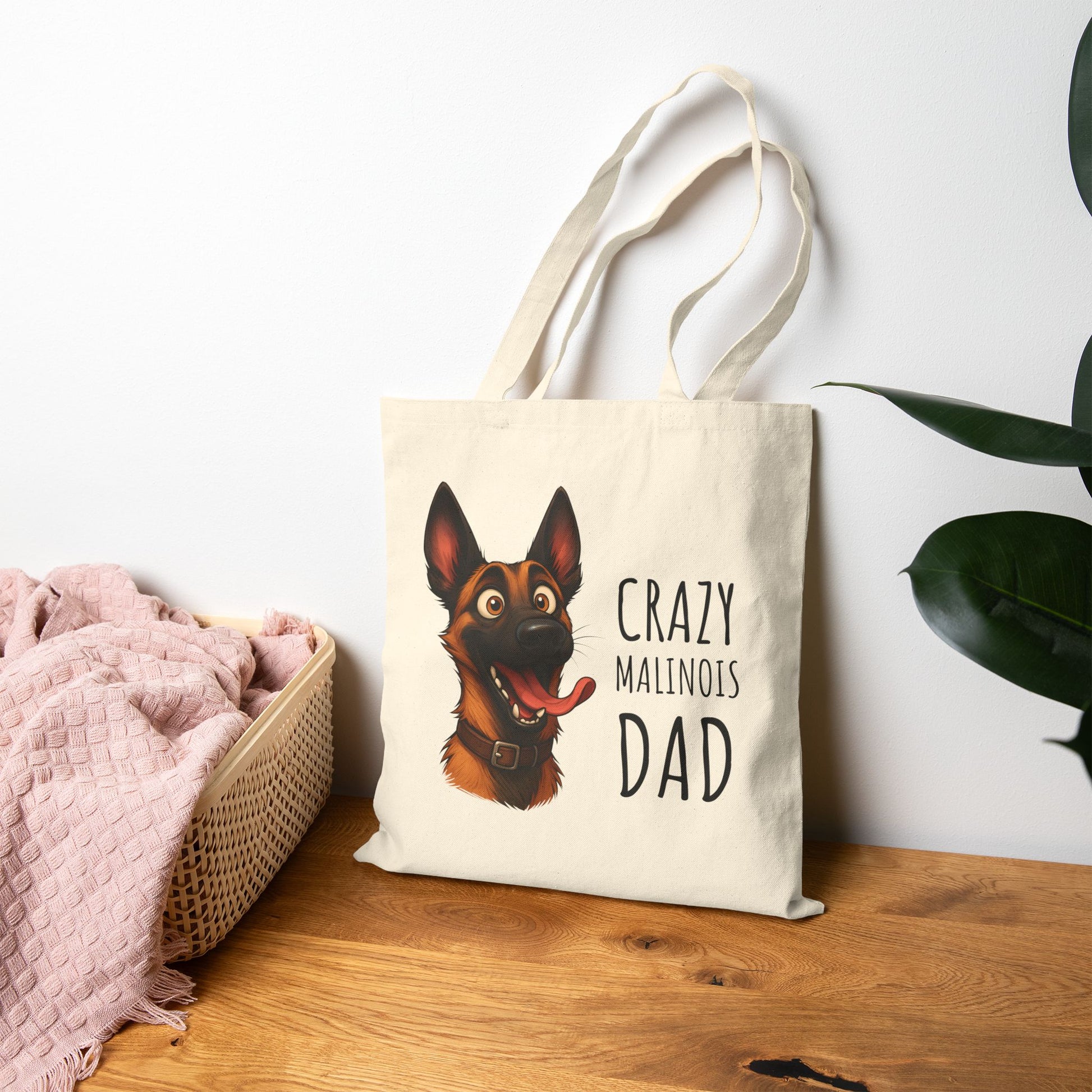 Tote bag with a dog illustration and text on a wooden surface with a plant in the background