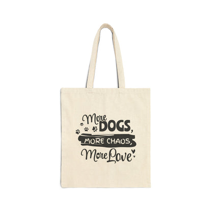 Beige tote bag with black text 'More Dogs, More Chaos, More Love' on a white background