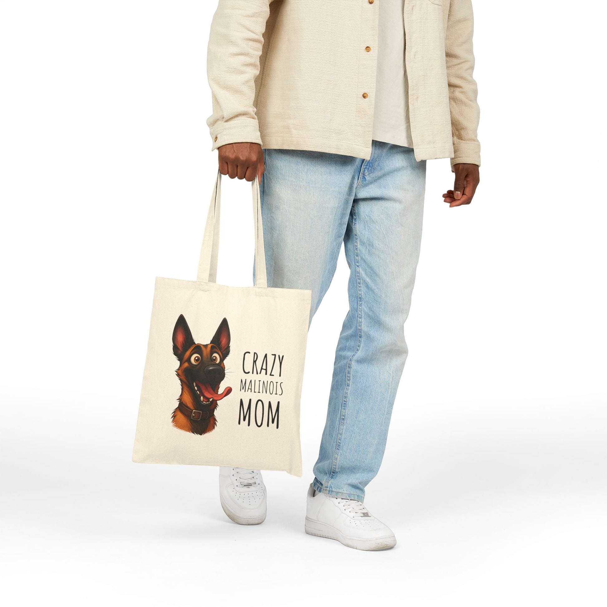 Person holding a tote bag with a dog illustration and text on a white background
