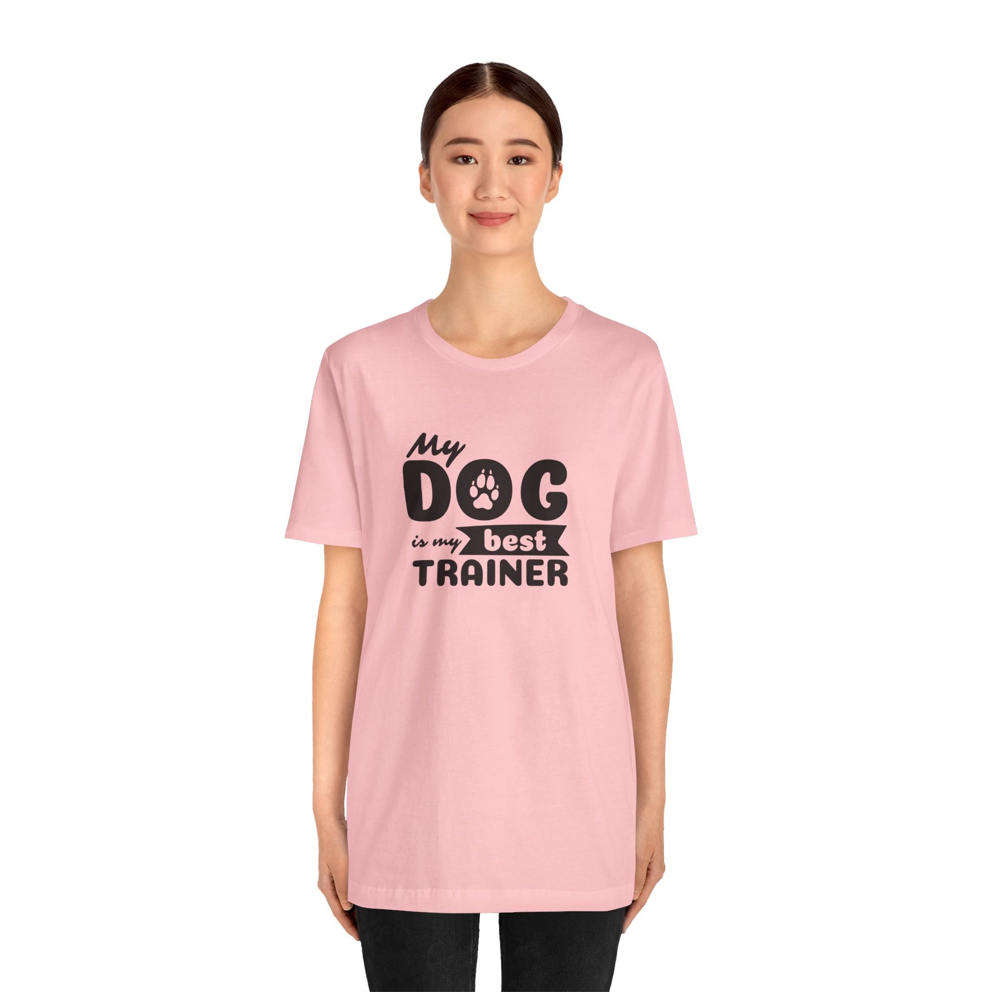 Person wearing a pink t-shirt with 'My dog is my best trainer' text on a white background