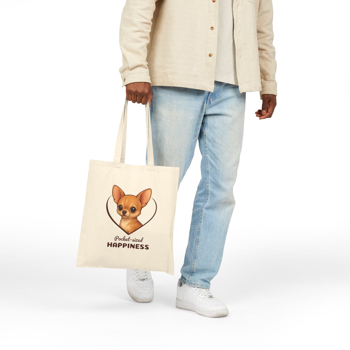 Person holding a tote bag with a dog illustration and text on a white background